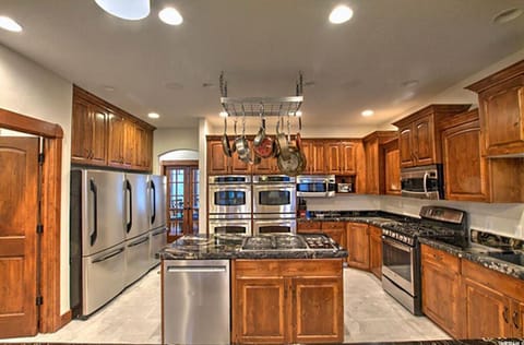 Large gourmet kitchen. 2 gas stove tops, 5 ovens, and 3 fridges.