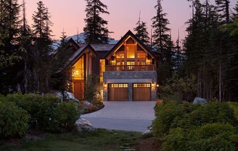 - Warmly lit chalet exterior surrounded by twilight forest charm  
- Inviting glow creates a magical mountain evening ambiance  
- Perfect retreat for cozy nights and starlit mountain skies  