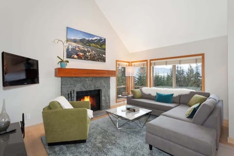 - Bright living room with a crackling fireplace and panoramic mountain views  
- Plush sectional sofa and stylish décor creating a warm inviting space  
- Ideal for relaxing after skiing or hiking adventures 