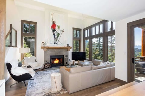 - Cozy living area with a glowing fireplace and scenic mountain views  
- Large windows fill the space with natural light and warmth  
- Ideal gathering spot for family evenings and après-ski moments  