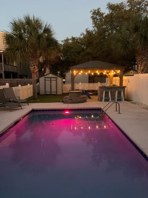 Evenings by the pool under the lights — relax after a beach day.