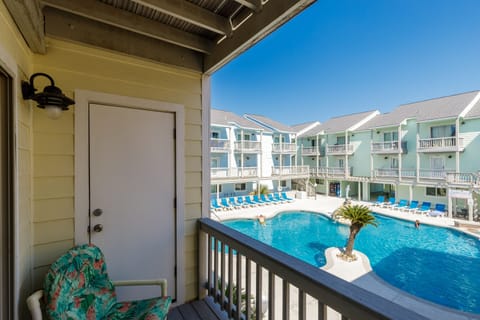Step onto your private balcony and soak in the sparkling pool views below, where tropical vibes meet coastal comfort in this perfect poolside retreat.