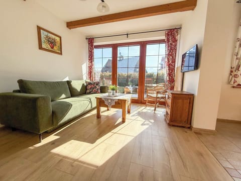 Sunny living room with green sofa and cosy space.