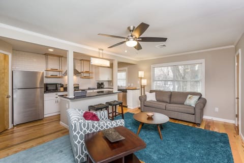 Modern, open kitchen/living area with large TV