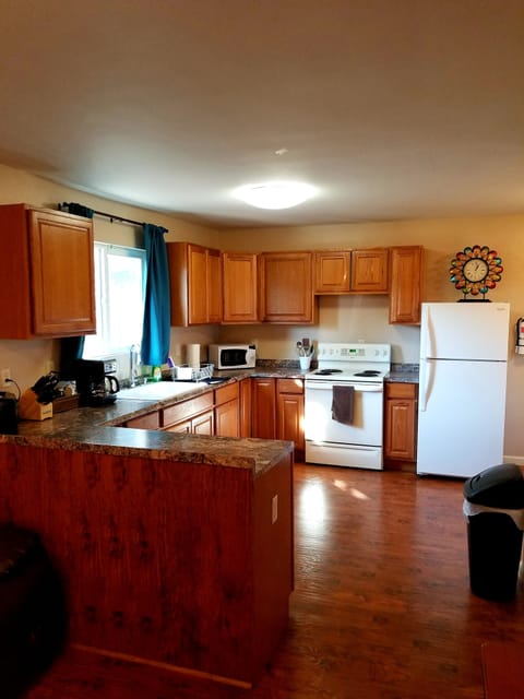 Large kitchen with fridge, stove, microwave, toaster, and coffee maker.