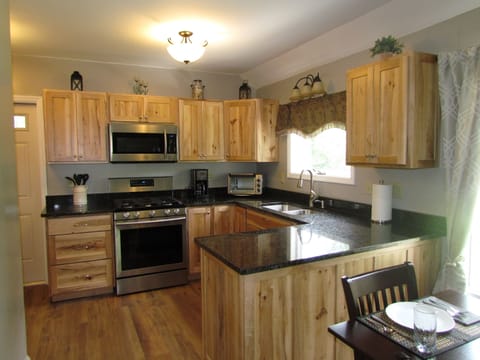 Fully equipped kitchen featuring rustic maple cabinets and granite counter tops.