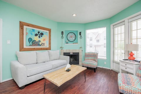 Your bright living space features cheerful turquoise walls, cozy seating, and a warm fireplace for perfect relaxation after coastal adventures.