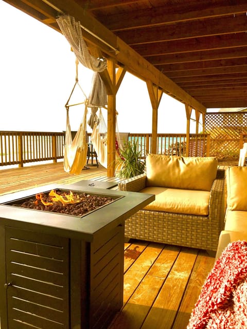 Luxury patio furniture, firepit, and hammocks on deck overseeing the lake
