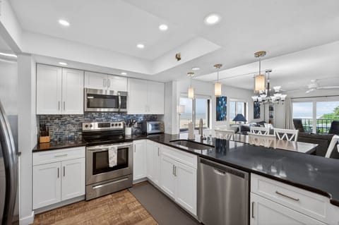 Sleek kitchen w/ stainless appliances, ample counters, & bright lighting for easy meal prep.