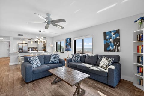 Spacious living room w/ comfortable sofas & ceiling fan for laid-back lounging.