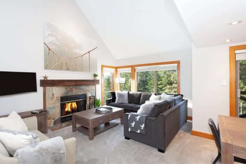 - Bright and modern Whistler living room with cozy fireplace  
- Large windows with forest views for a peaceful retreat  
- Perfect family space for après-ski relaxation  
