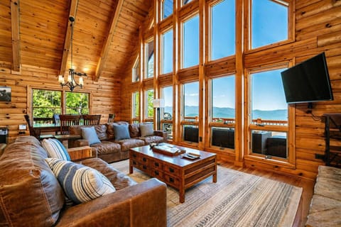 Open concept living & dining room with floor-to-ceiling windows offering up stunning mountain views.
