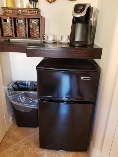 Coffee maker with pods provided and a stocked mini-fridge
