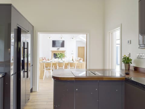 Spacious kitchen with open-aspect pocket doors to living areas | Manor Lodge Stables, Wiston, near Haverfordwest