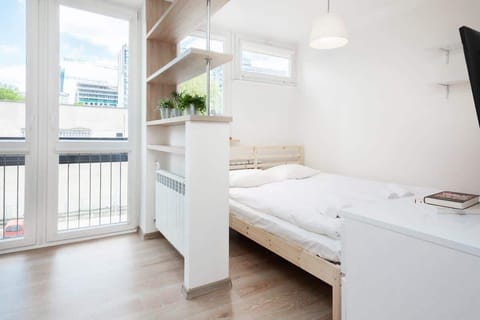 A close-up of the double bed with soft bedding, showing its placement by a bright window.