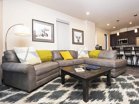 Unwind on this plush sectional sofa with colorful pillows while you enjoy the open-concept layout flowing into your modern kitchen.