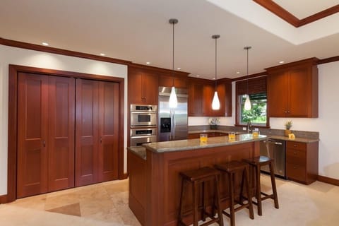 Full kitchen with breakfast bar, granite counters, and stainless steel appliances