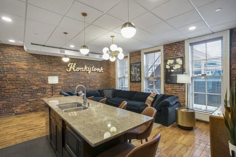 - Bright open layout with large sectional and Nashville wall sign for added vibe - Brick walls and modern lighting create a stylish living area for guests - Ideal social space for relaxing nights and group hangouts in the city