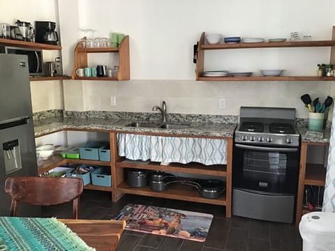 A fully stocked kitchen. Refrigerator, stove, coffee pot, plates-we have it all.