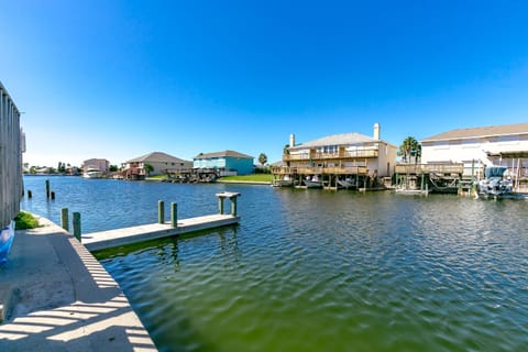 Waterfront canal community with private docks and elevated beach houses under clear blue skies.