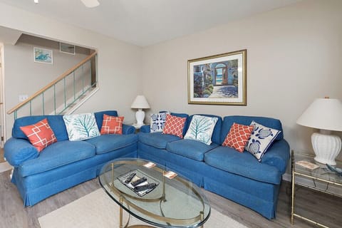 Living room with blue sofa, colorful cushions, and coffee table