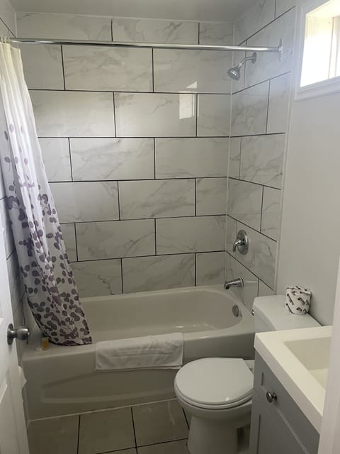 Economy Double Room, 2 Queen Beds | Bathroom | Combined shower/tub, rainfall showerhead, bathrobes, towels
