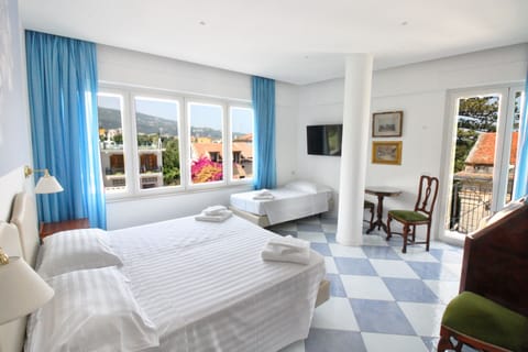 Triple Room | Minibar, in-room safe, desk, blackout drapes