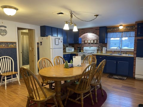 Bright kitchen space with classic cottage decor, perfect for family meals and gatherings! Also show entryway to bathroom and bedroom 2.