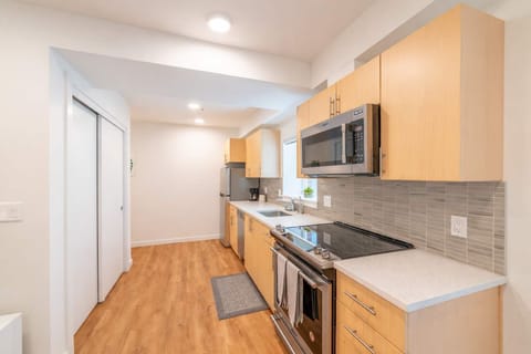 Sleek galley kitchen with stainless appliances, quartz counters, and plenty of storage—ideal for easy meals and longer stays.
