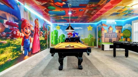 Vibrant game room with themed decor, pool table, foosball, and arcade fun.