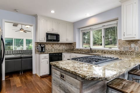 Kitchen with huge windows and beautiful cream cabinets and designer finishes.