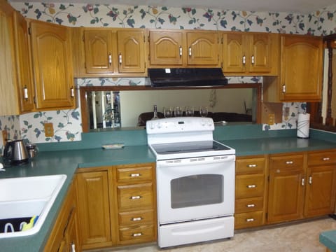 spacious kitchen, GE stove & oven, coffee maker, tea pot, multiple utensiles