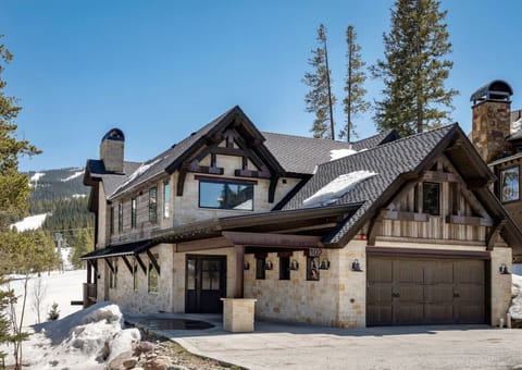 Framed by snow-dusted pines, the four-car heated garage and rugged stone façade welcome you into a true alpine escape.
