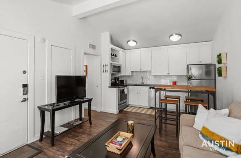 Living room with sleeper sofa and smart TV open to the kitchen