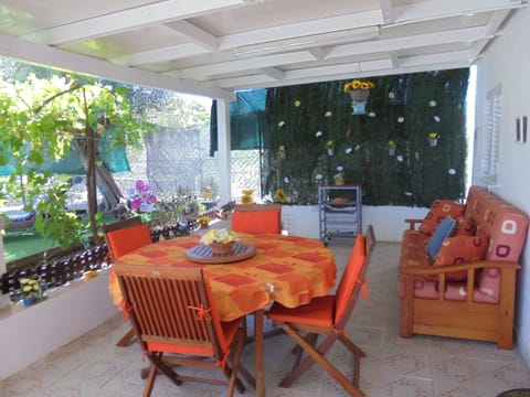 Foto do Alpendre, da mesa de refeições no exterior, e da decoração do mesmo.