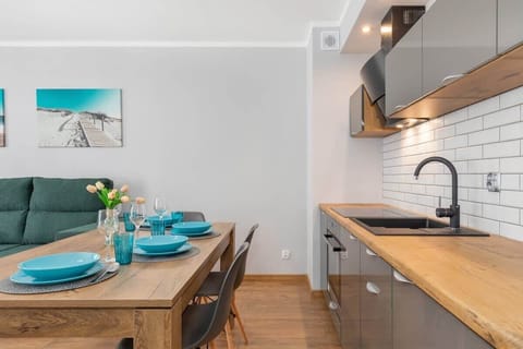 Dining area and kitchenette with an induction hob, kettle, oven and fridge.