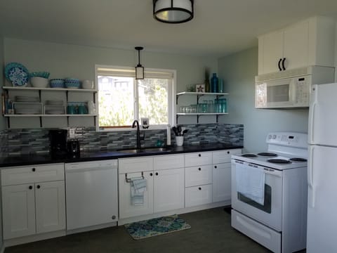 Full kitchen has a dishwasher, oven, fridge, microwave, coffee maker, toaster