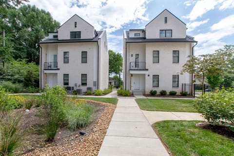 Exterior front of the white brick multi-unit building with a stone walkway
