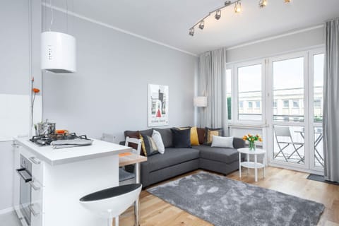 Living room with a sofa bed, TV and access to the balcony.