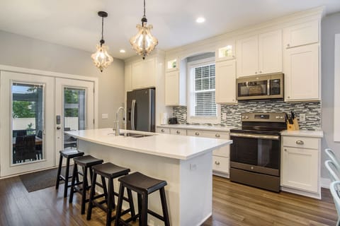 Well stocked kitchen with island seating and quartz countertops.