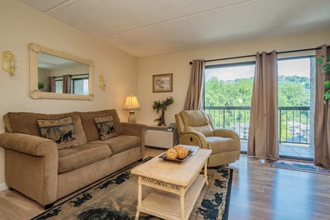 Unwind in your private living space, where warm tones and plush seating invite you to relax after a day of exploring. Through the balcony doors, lush greenery frames your peaceful retreat.