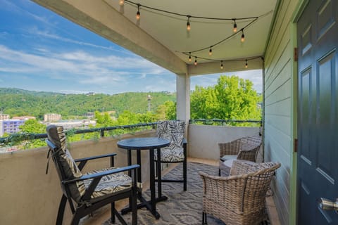 Sip your morning coffee on this covered balcony while soaking in stunning mountain views. Cozy seating and string lights create the perfect spot for relaxation.