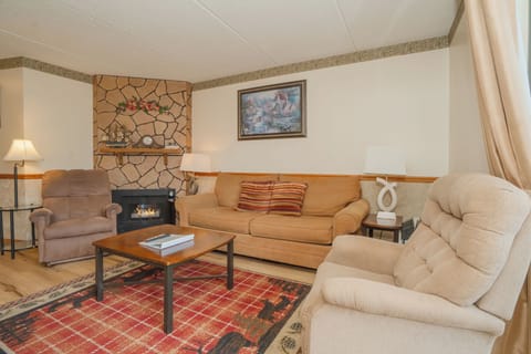 Gather around the warm fireplace and sink into plush seating in your cozy living room. The stone hearth adds rustic charm, while soft lighting creates the perfect atmosphere for relaxing evenings.