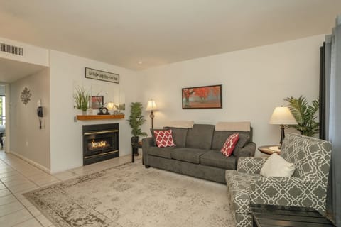 Unwind in your spacious living room, where a cozy fireplace and comfortable seating create the perfect retreat after exploring the area. Soft lighting and natural touches invite you to relax and feel right at home.