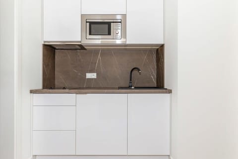 Kitchenette with microwave and electric kettle.