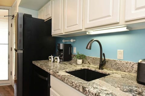 A fully equipped kitchen featuring sleek cabinetry, granite counters, and essential appliances