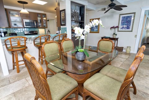 The dining area sits adjacent to the lanai, offering a seamless indoor-outdoor flow for family meals with ocean air drifting in.