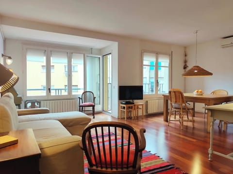 Relax in this bright, open-plan living space featuring warm hardwood floors and access to a sunny terrace.