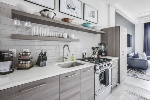 Kitchen with modern appliances and shelves full of bowls and cups.