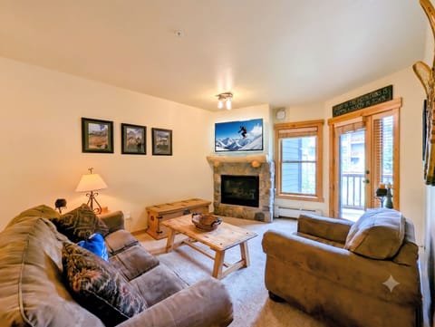 Sink into plush sofas by the stone fireplace, catch mountain views on the big screen, and step out to your private balcony—your cozy mountain retreat awaits.